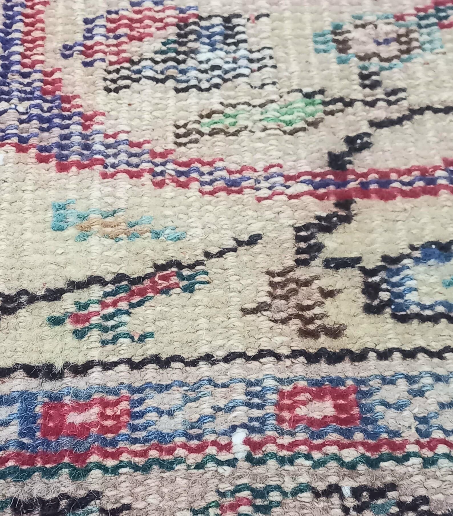 Macro detail of wool knots and fringe on a vintage rug.